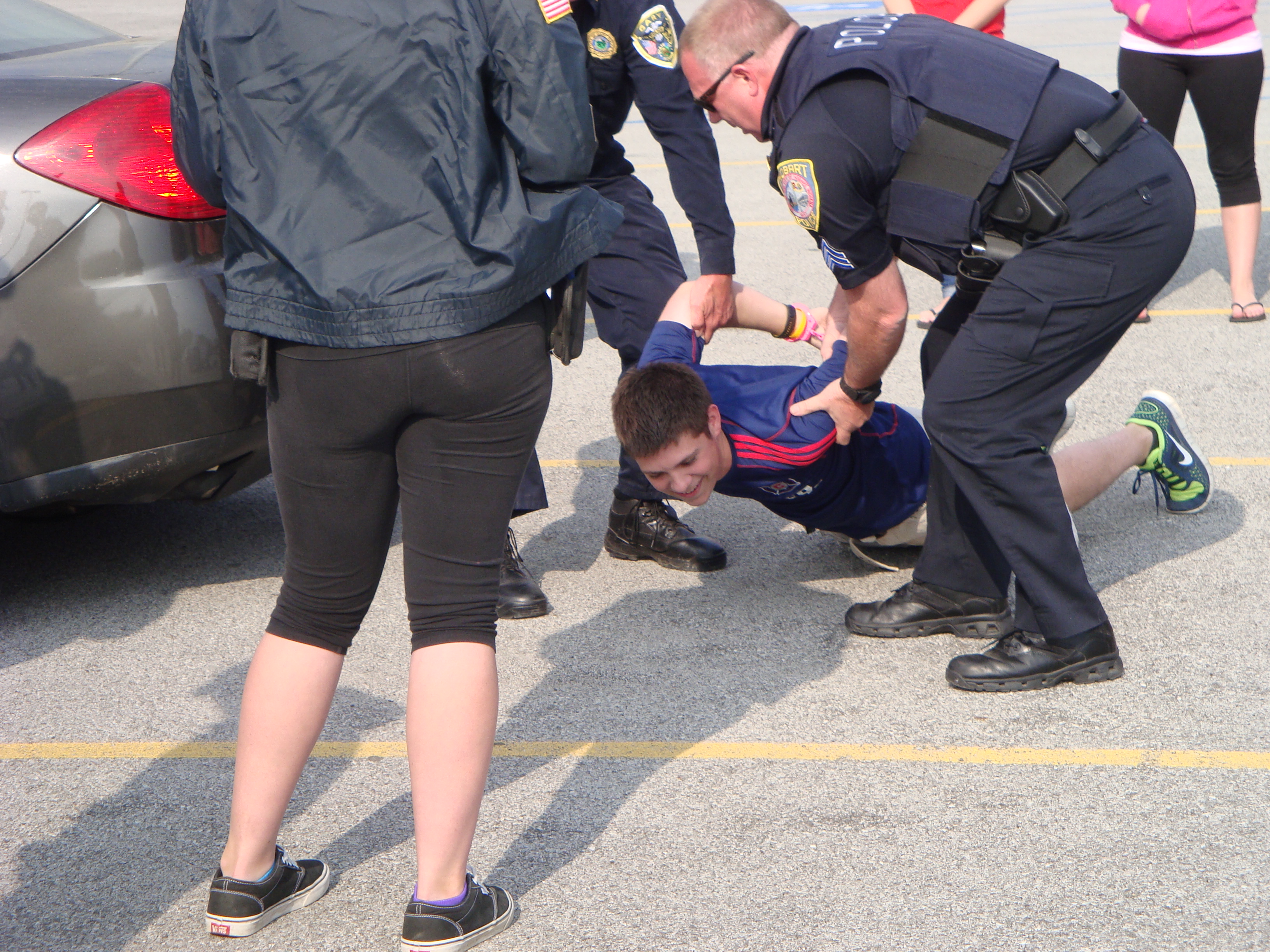 Officer's lifting student off ground